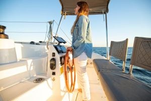 Woman at helm sailing Excess 11 catamaran