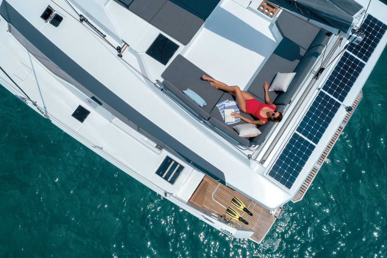 Uptop view of Elba 45 catamaran with woman relaxing on cockpit