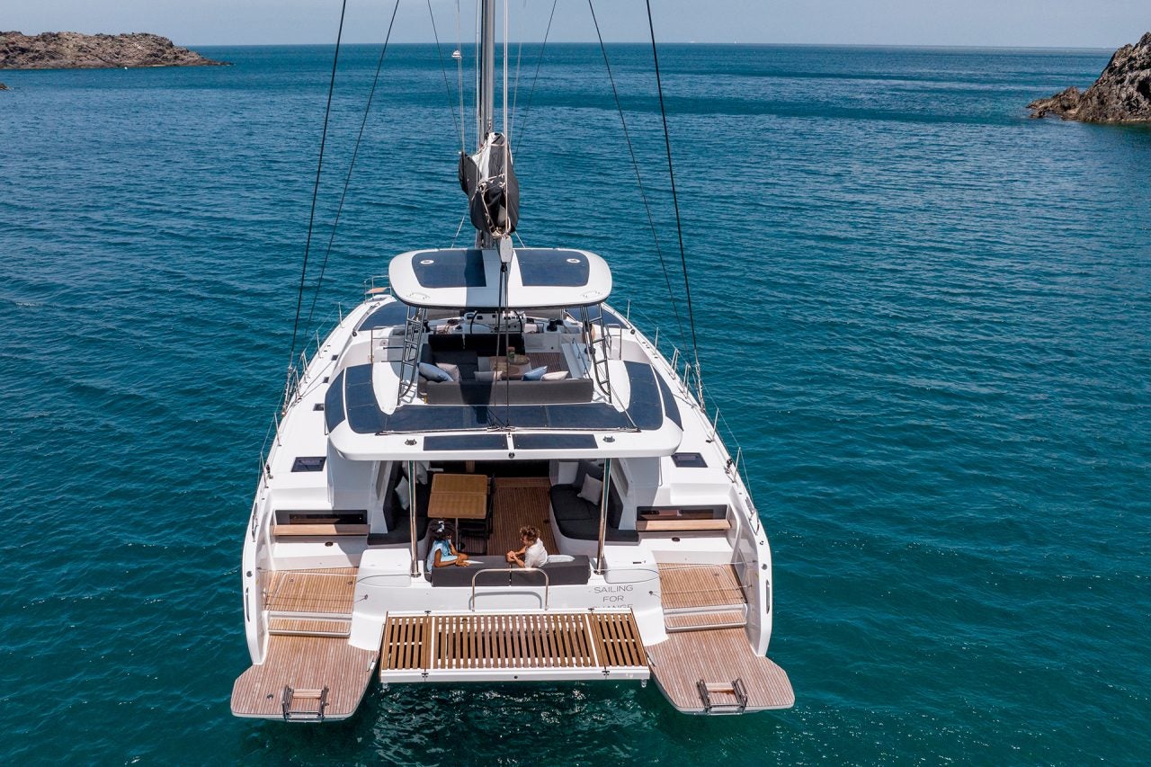 Lagoon 51 yacht at anchor with couple on deck and swim platform