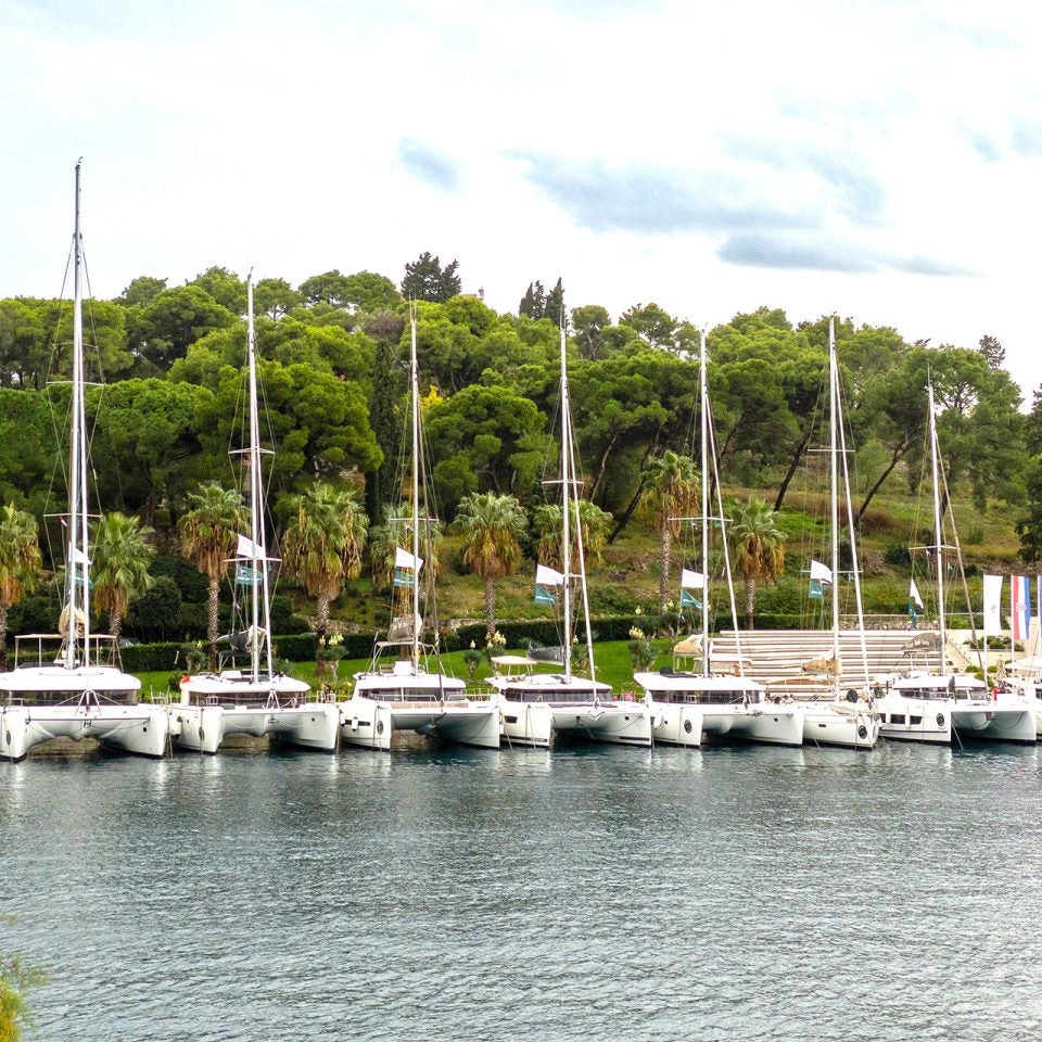 Dream Yacht fleet of sailing catamarans docked along a quay.