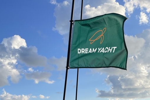 Dream Yacht branded flag waving against a blue sky.