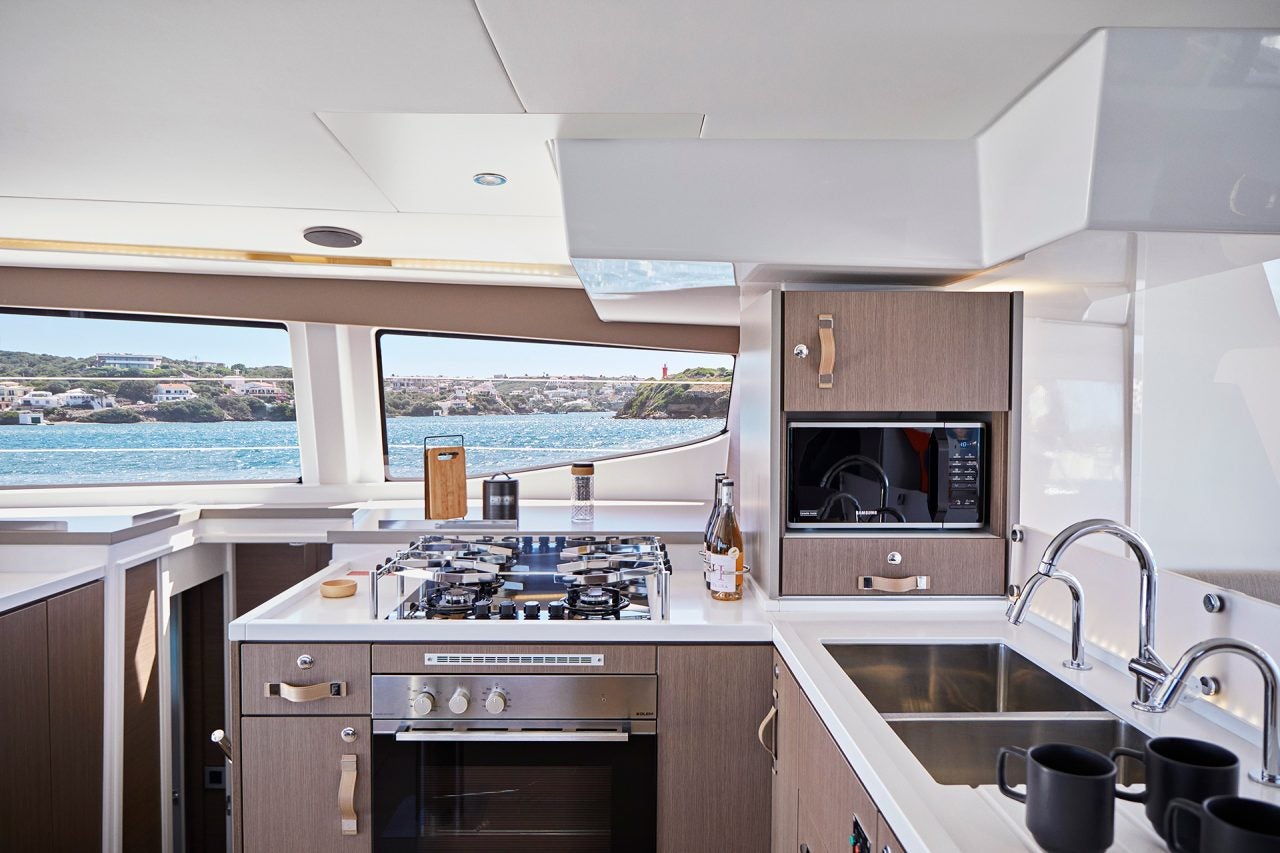 Large light wood kitchen with large windows aboard the Bali 4.8