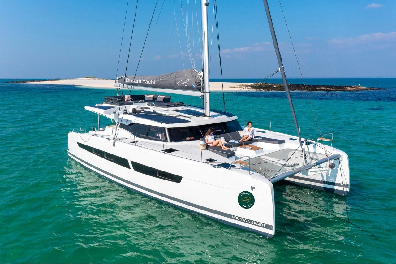 Dream Yacht electric sustainable catamaran anchored near sandy island