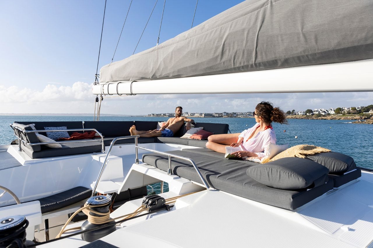 Couple on flybridge lounge area on the Fountaine Pajot Aura 51 catamaran