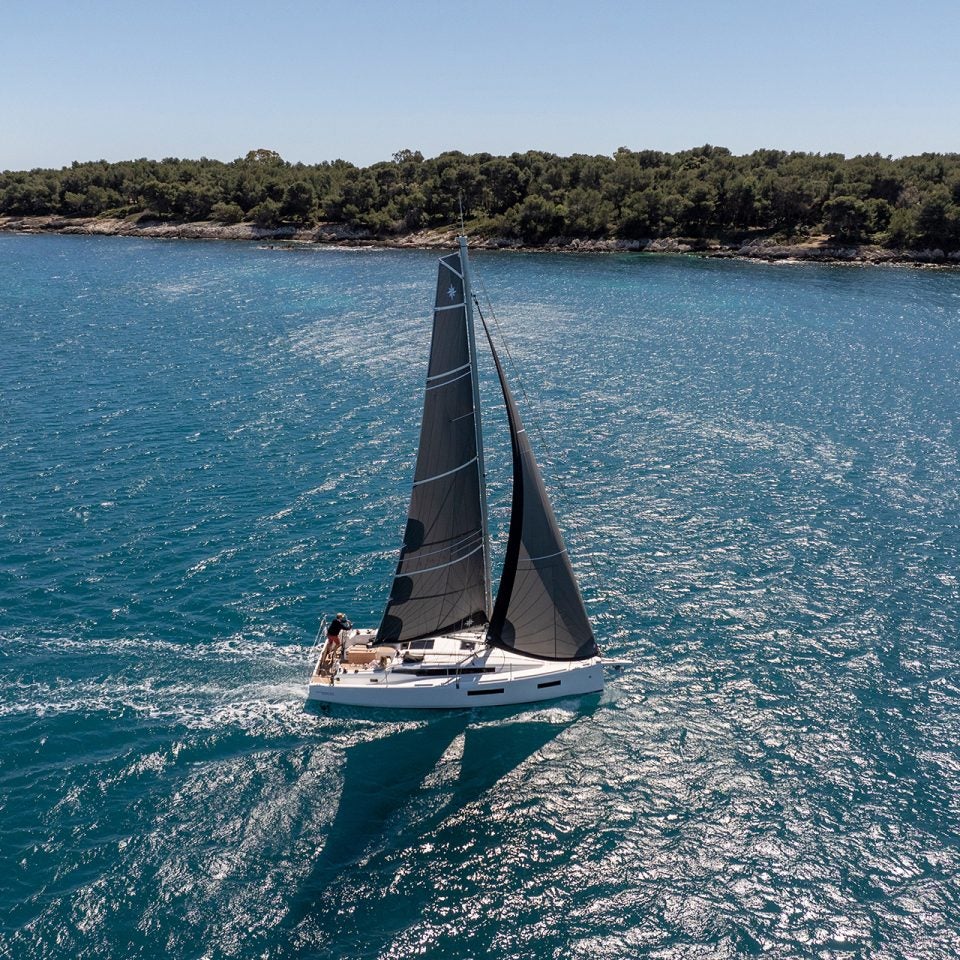 Sun Odyssey 350 sailing monohull at sail near coast