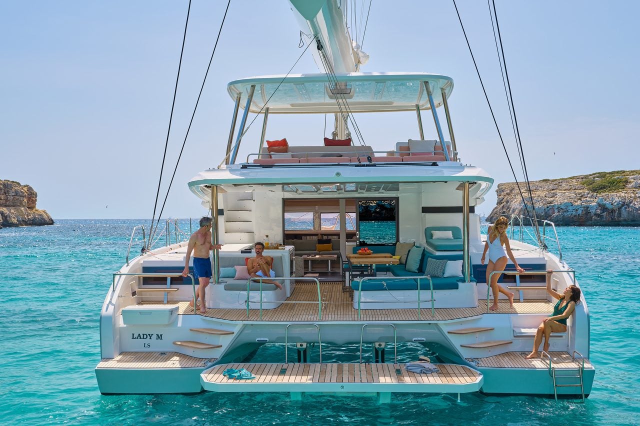 Rear view of people aboard the Lagoon 55 luxury catamaran at anchor