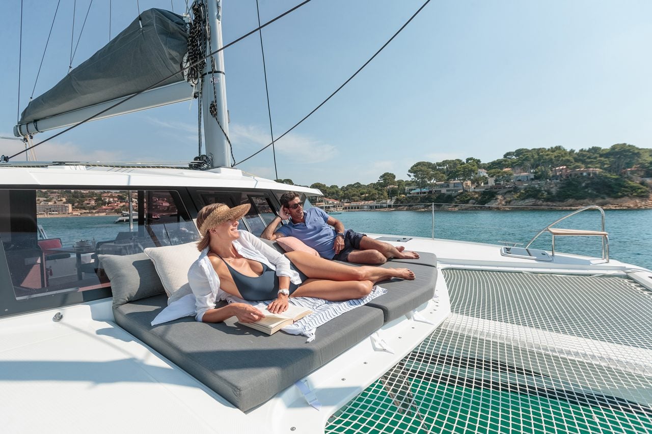 Couple on front deck lounger of the Fountaine Pajot Isla 40 catamaran